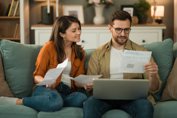 istock Happy couple paying their bills online at home. 2155230685