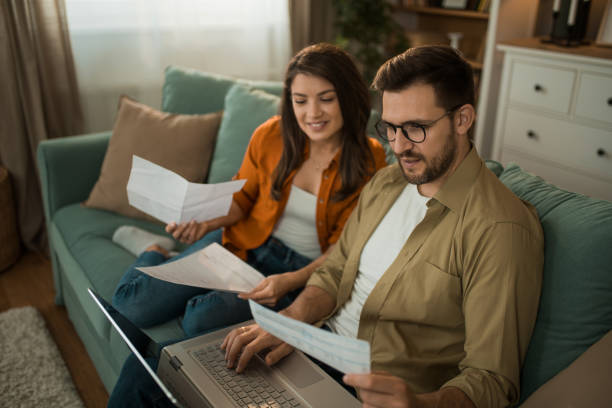 istock Happy couple paying their bills online at home. 2155230698