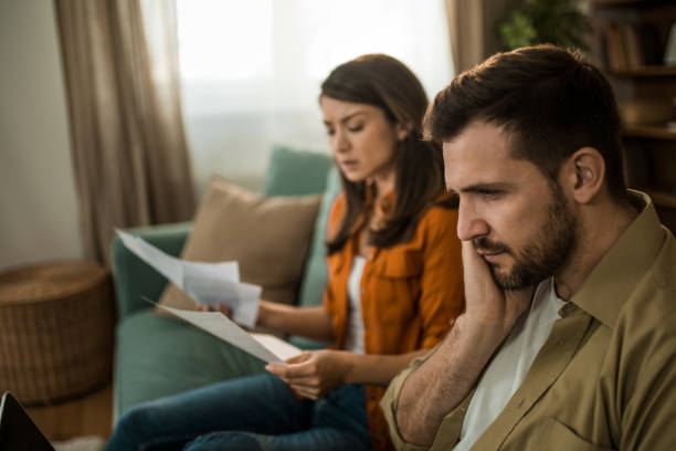 istock Worried couple paying their bills over a computer at home. 2155231038