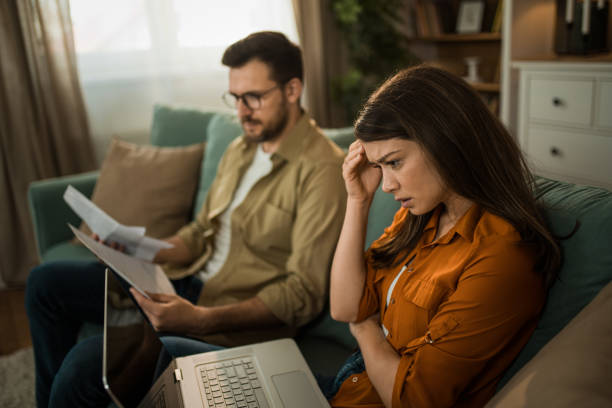 istock Worried couple having problems with their financial bills at home. 2155231207
