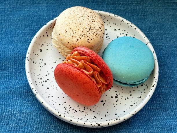 istock Macarons on the white plate on the jeans background 2155241812