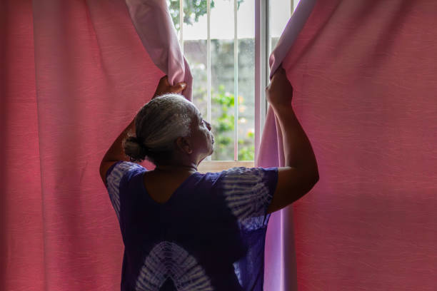 Older black woman closing bedroom window