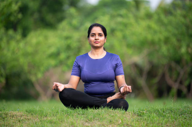 istock Young woman practicing yoga in park 2155246872