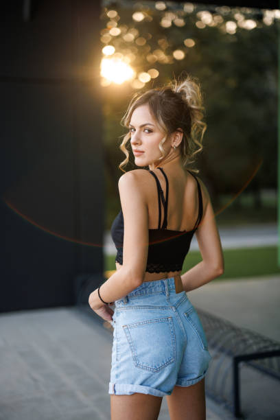 Portrait of beautiful young woman at summer sunset in the city