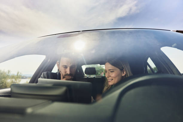 istock Business colleagues working on a computer in a car. 2155247580