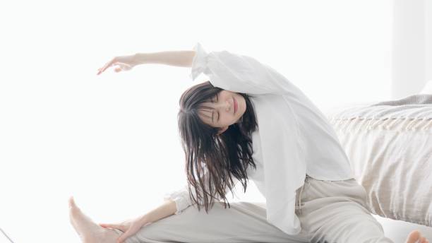 istock Asian woman stretching in bedroom 2155249680