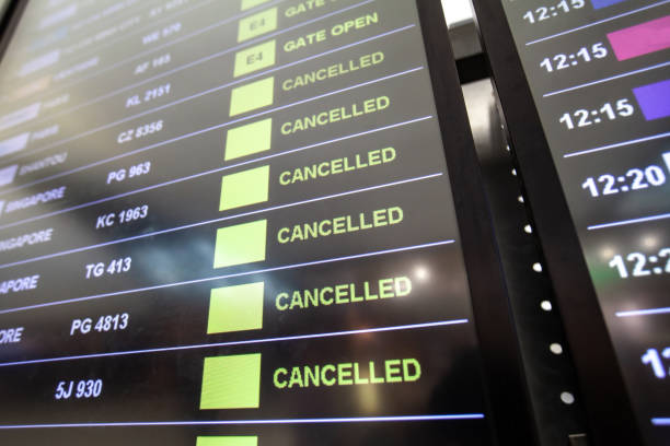 flight cancellations in airport on departure board screen, cancelled trip due to coronavirus COVID-19