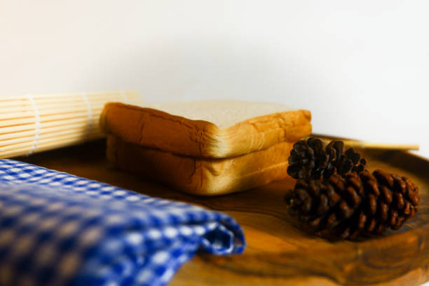 photography of white bread on a wooden coaster with a white background