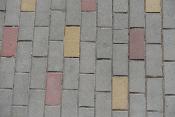 An abstract close-up of worn colorful pavement tiles. The faded yellow and purple blocks and soft focus evoke nostalgia, memory, and the passage of time, making it suitable as an urban background or conceptual texture.