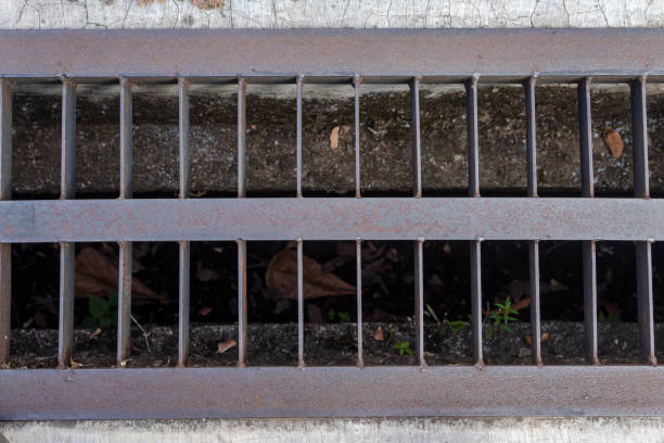 Iron grille along a sidewalk. Drainage system for storm water drainage from a pedestrian sidewalk