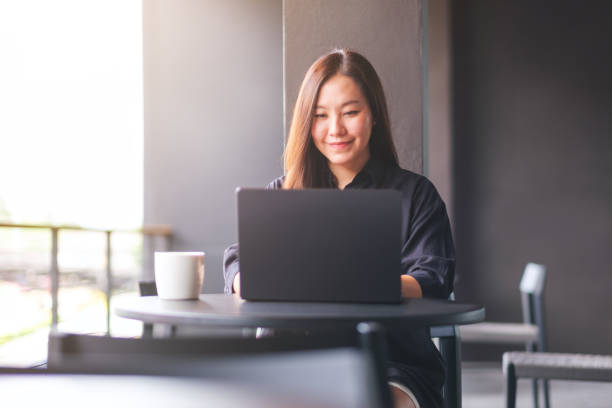 istock Portrait image of a young woman working on laptop computer in cafe 2155254647