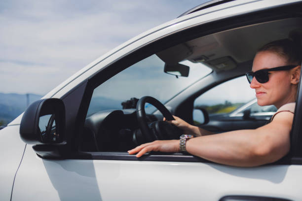 istock Woman driving a white car on a sunny day 2155261799
