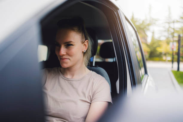 istock Woman sitting in car driver's seat looking out window 2155261907