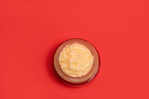 istock Face cream in glass cosmetic jar on a color background 2155264091