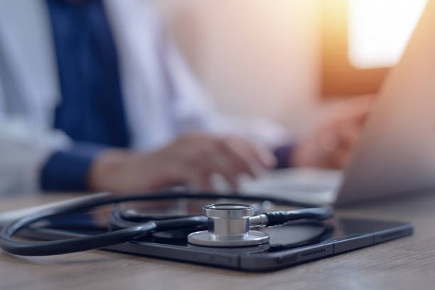 istock Close-up of doctor working on laptop computer with digital tablet on table in doctor's office medical and health care concept 2155264366