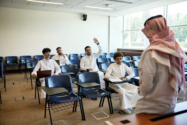 istock Young male student answering while sitting with pupils on chairs in lecture hall 2155267277