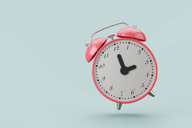 istock A pink alarm clock with a white dial and black numbers. set at  3:00. on gray backgroud. 2155269782