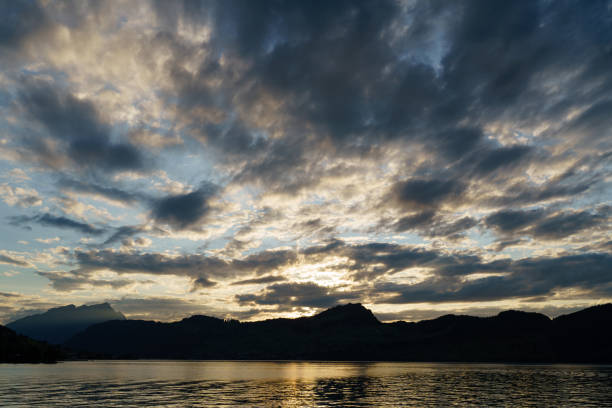 Landscape of mountains and lake at sunset and clouds reflected in the water.