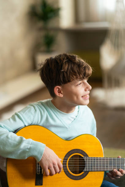 istock Teenage boy playing guitar 2155271521