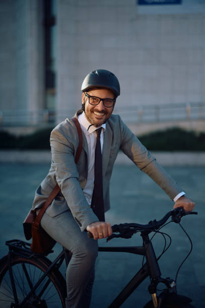 istock Happy businessman riding bicycle and looking at camera. 2155272259
