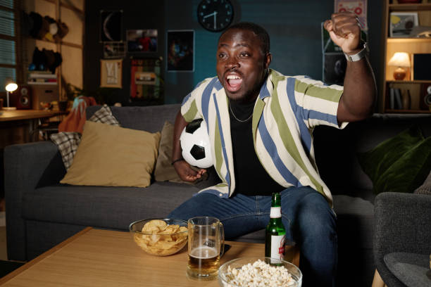 istock Cheerful Black Man Watching Soccer Match 2155273609