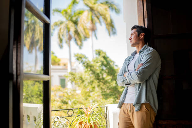 istock Mid adult man contemplating on a apartment's balcony 2155273623