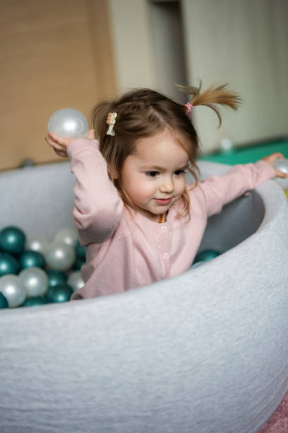 istock Little girl having fun playing in ball pool 2155273699