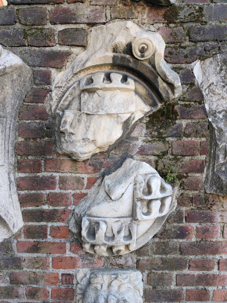 istock Red brick wall background with stone marble aged sculptures. 2155274652