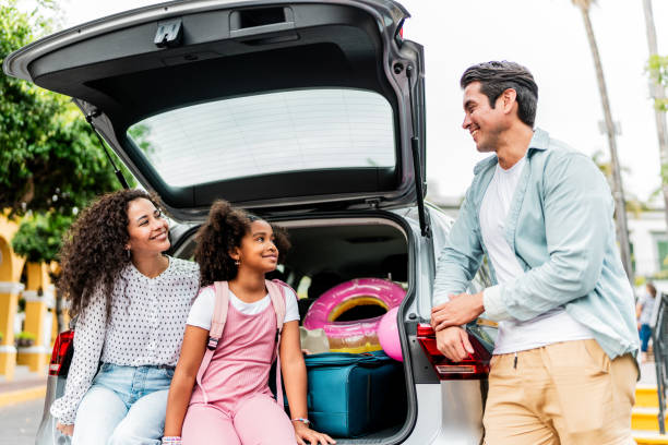 istock Family talking next to open car trunk outdoors 2155274697
