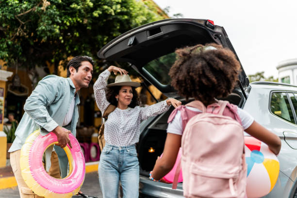 istock Family unloading luggages from the car trunk 2155274745