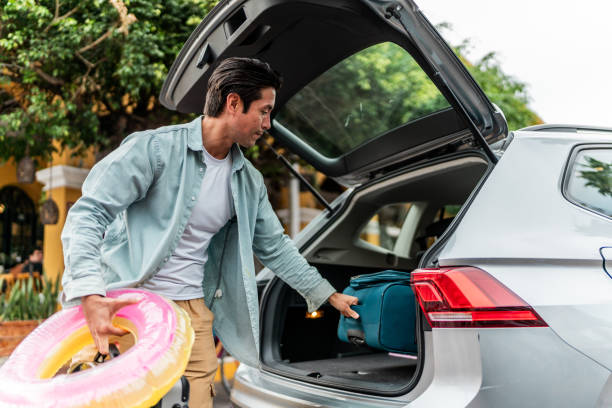 istock Mid adult man unloading luggages from the car trunk 2155274767