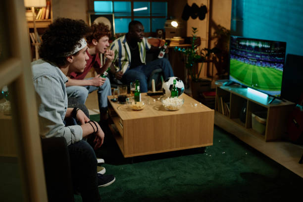 istock Young People Watching Soccer On TV 2155275557