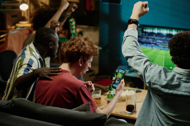 istock Happy Soccer Fans Watching Match On TV 2155276046