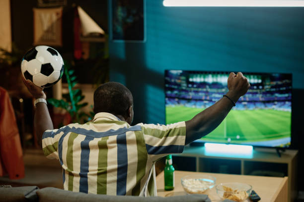 istock Black Guy Watching Soccer Game On TV 2155276370