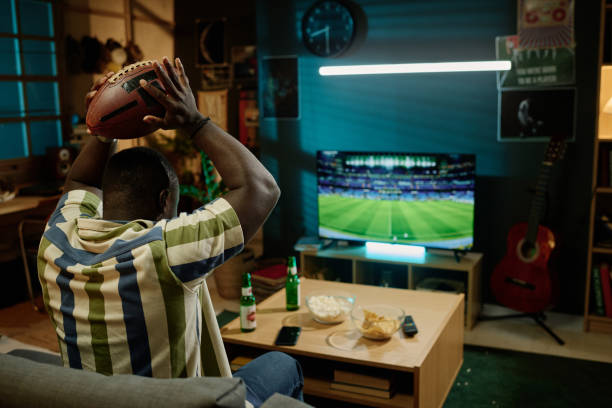istock Young Football Fan Watching Match On TV 2155276498