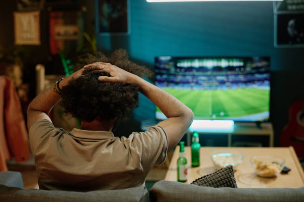 istock Disappointed Man Watching Soccer Gamer On TV 2155276500