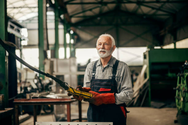 istock An older heavy industry worker is working at factory while manipulating machine. 2155277040