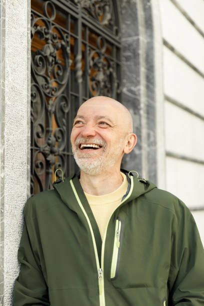 istock Content Senior Man Smiling in Sunlit Urban Environment Wearing Green Jacket 2155277132