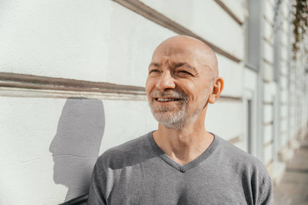 istock Smiling elderly man standing against a lined wall on a sunny day 2155277987