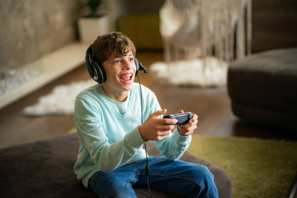 istock Excited teenage boy playing video game 2155278534