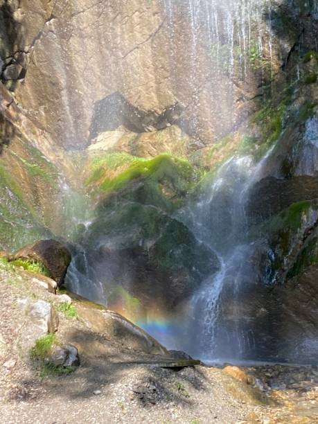 istock Closeup of an Alpine water fall with a rainbow 2155287443