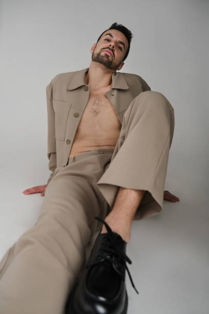istock medium shot of a serious caucasian handsome Millennial generation man sitting on the ground modeling proud looking at the camera 2155288021