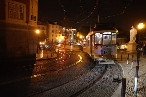 A tramway snakes its way through the streets of Lisbon at night.  The city is world renowned for its expansive tramway lines.