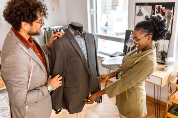 istock Two tailors working on a new suit in tailor shop. 2155289065
