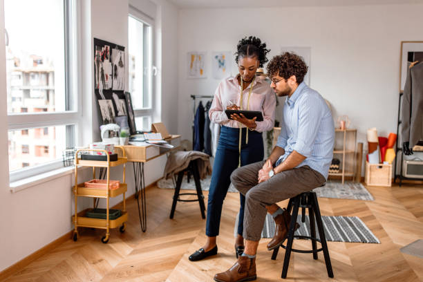 istock Female tailor consulting with a client in a tailor shop. 2155290563