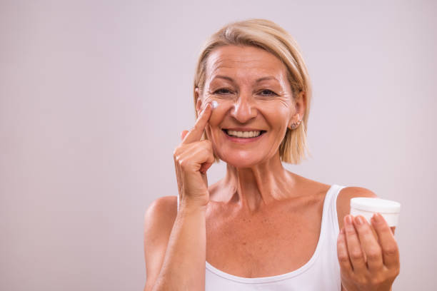 istock Mature woman applying moisturizer on face 2155292168