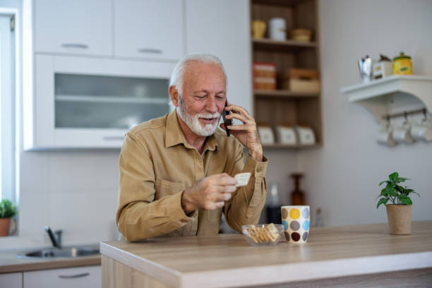 istock Coffee, phone and elderly man in kitchen talking on the phone in his home. Happy, communication and 5g network with senior male enjoying fast internet and online app conversation. 2155292694