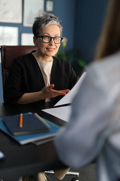istock In a professional office setting, a group of businesspeople, including a confident businesswoman, discussing career and projects. 2155293296