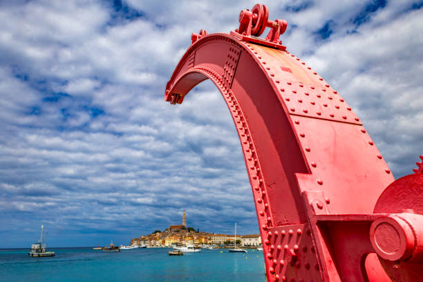 Red old historic crane in the port unloading ships panorama view of Rovinj Croatia