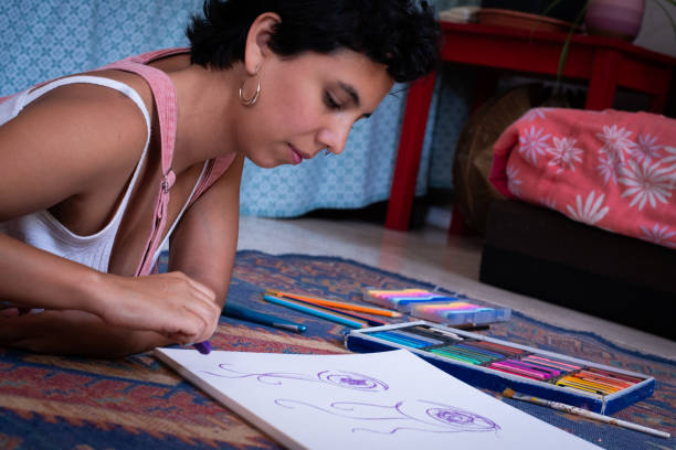 Creative Young Woman Using Pastels on Living Room Floor at Home